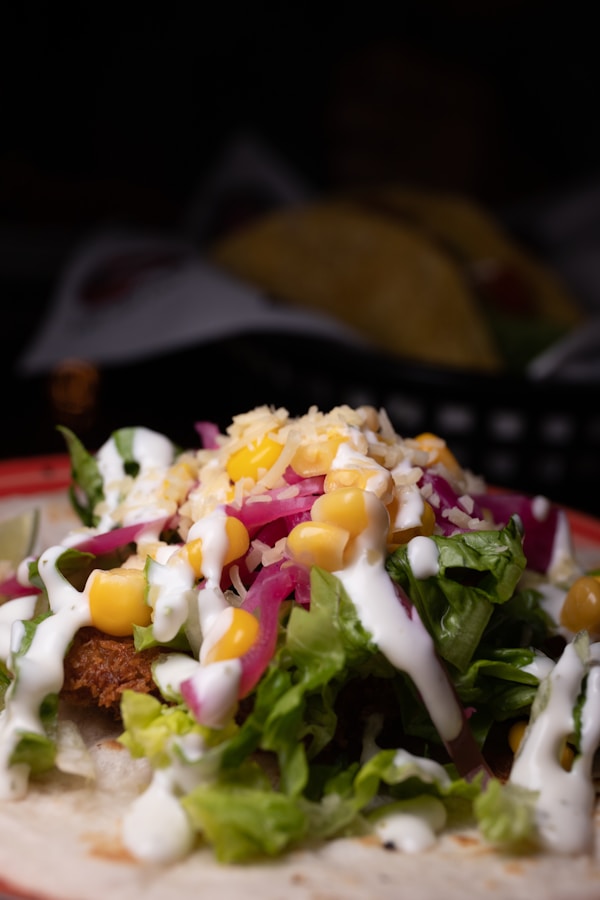 A taco filled with lettuce, corn, and dressing