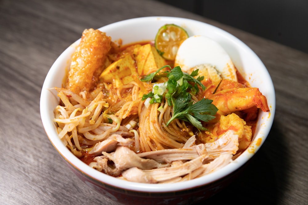 a bowl of noodles with meat and vegetables