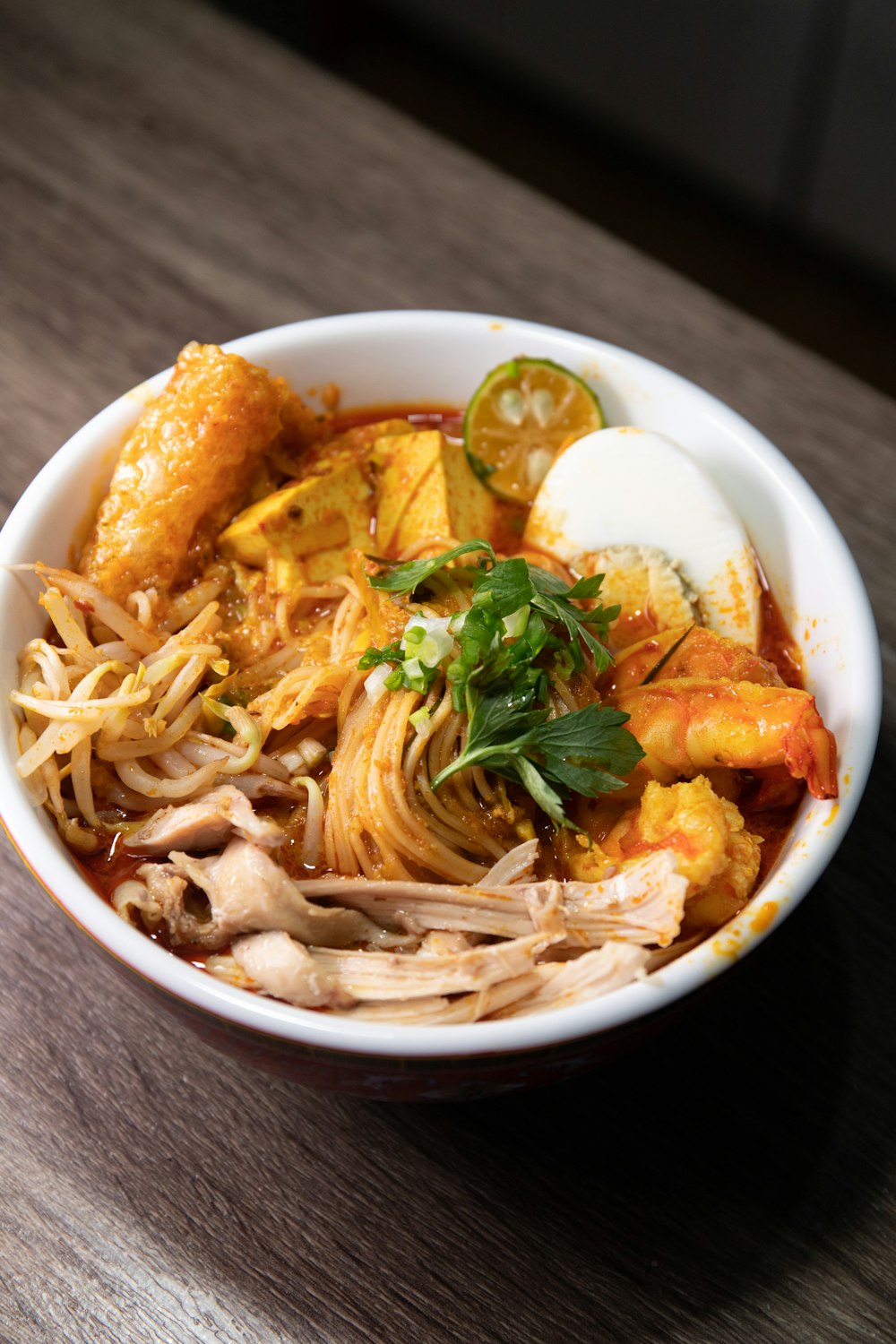 a bowl of food with noodles, meat, and vegetables