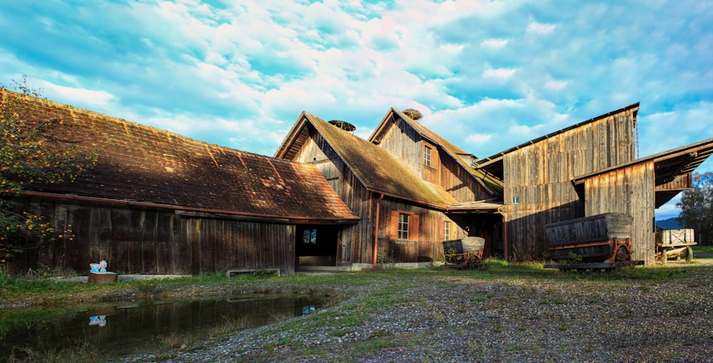 an old barn with a pond in front of it