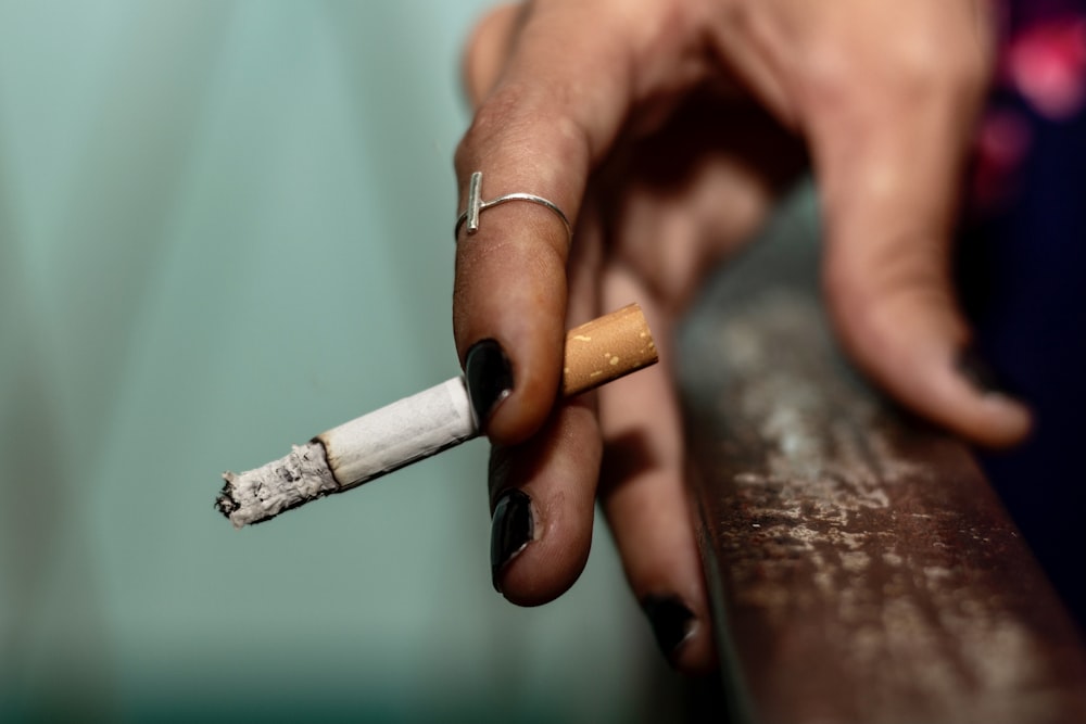 a person holding a cigarette in their hand