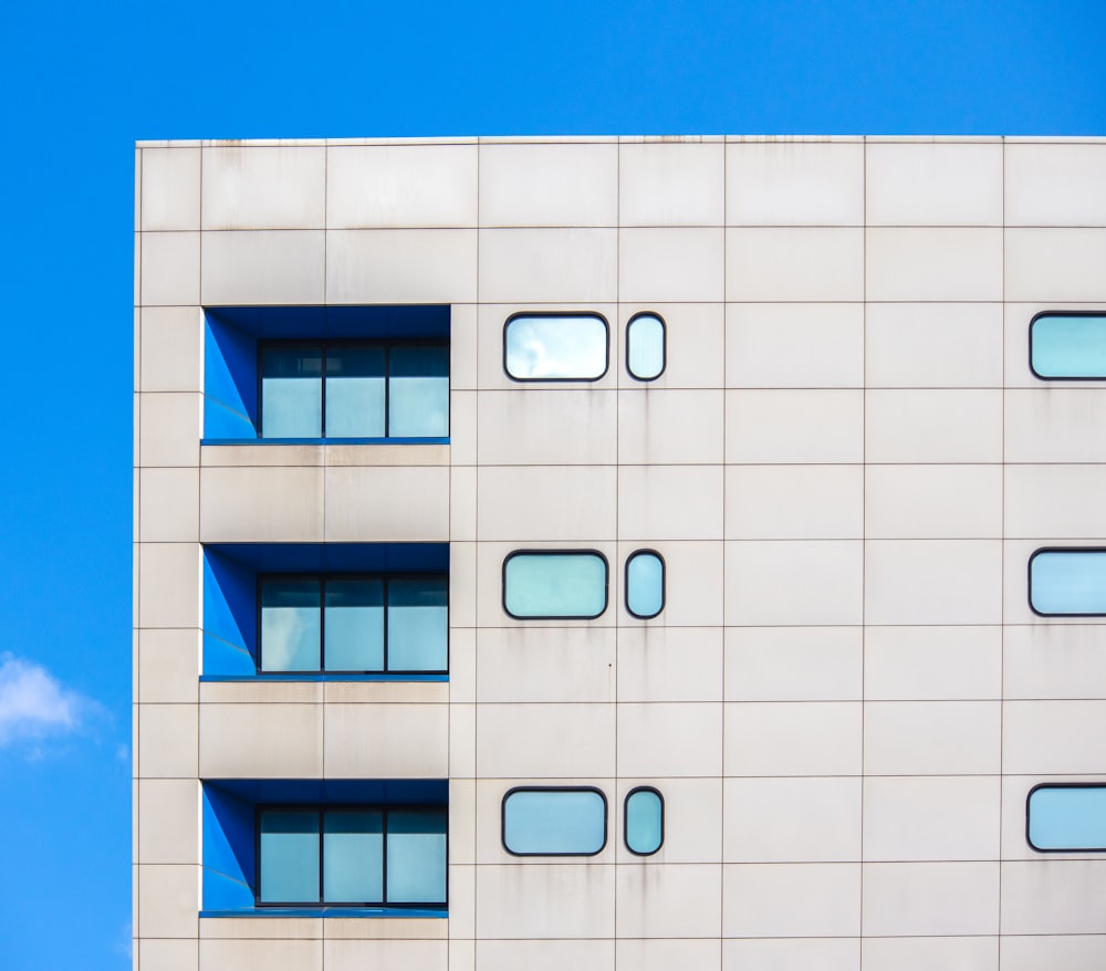 a white building with windows and a blue sky in the background
