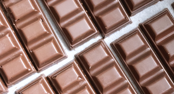 several rows of chocolate bars lined up on a table