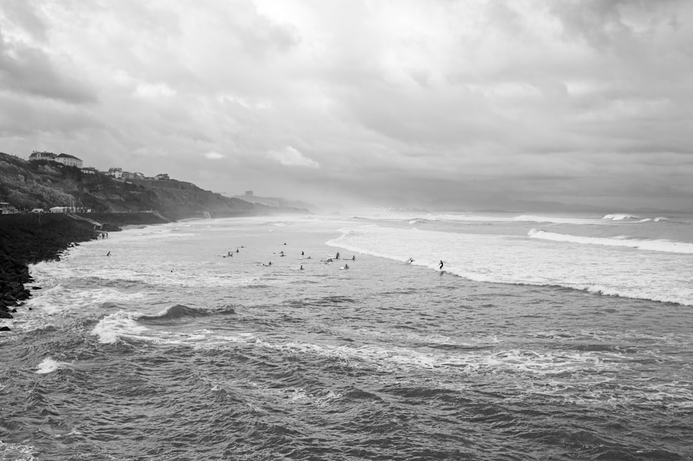 a black and white photo of surfers in the ocean