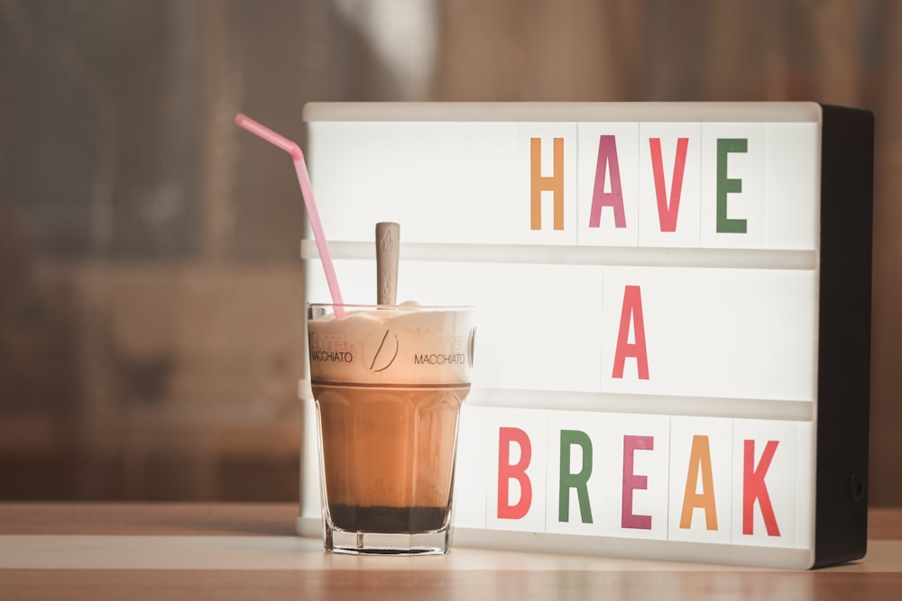 a drink sitting next to a sign that says have a break