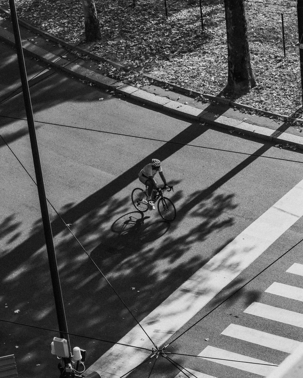 a man riding a bike down a street next to a cross walk