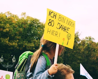 a woman holding a sign that says i am sorry