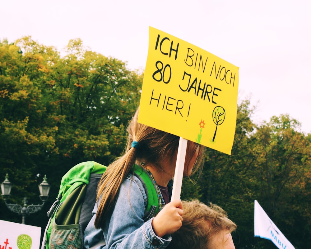 a woman holding a sign that says i am sorry