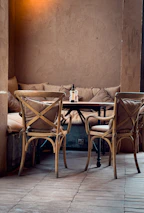 A cozy corner of the restaurant with deep brown leather seats and golden light accents.
