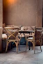 A cozy, warmly lit corner of Casa Pablo with rustic wooden tables and red and yellow accents.