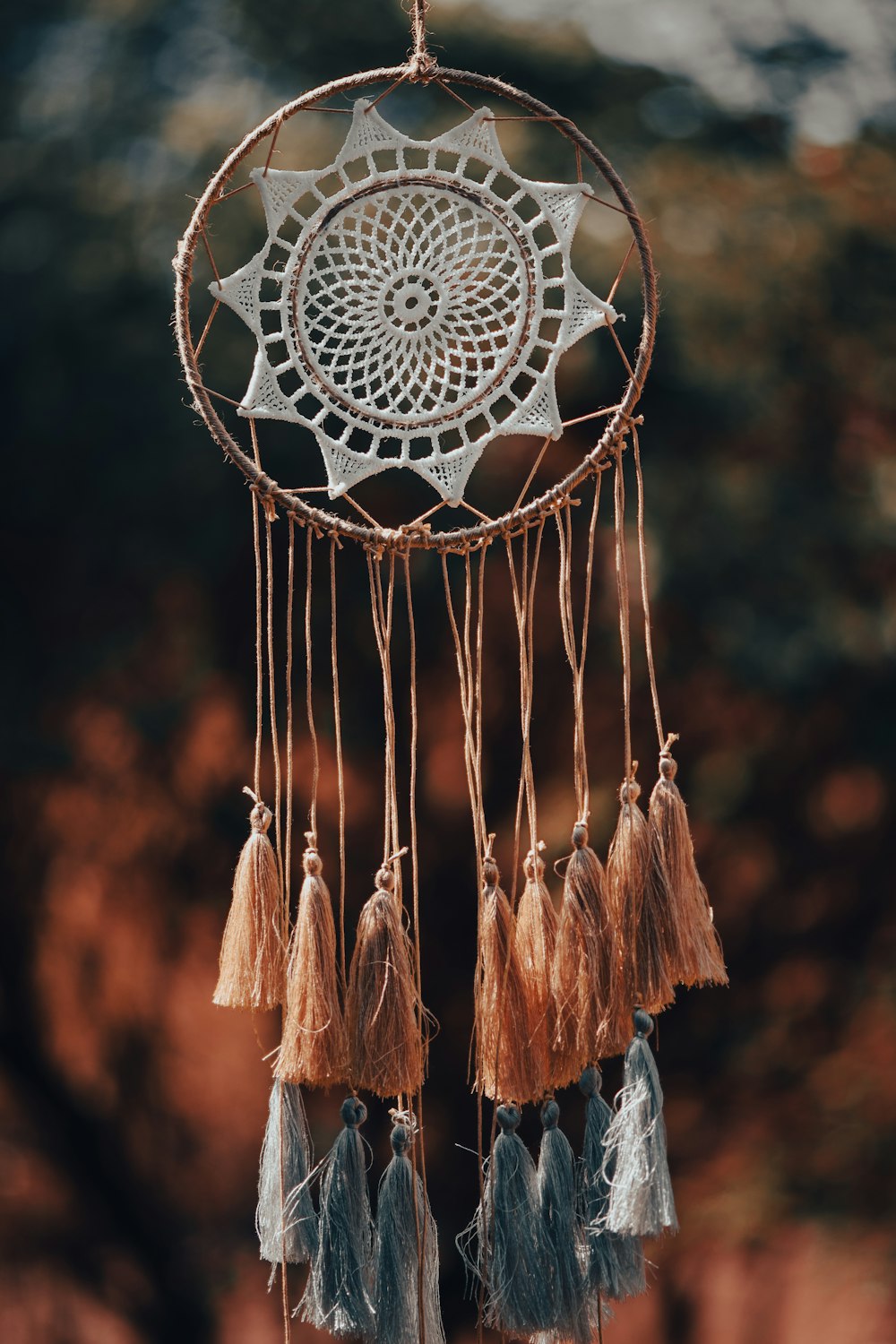 a dream catcher hanging from a rope with tassels
