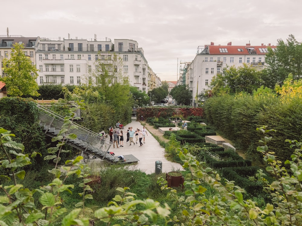 a group of people walking down a walkway in a park