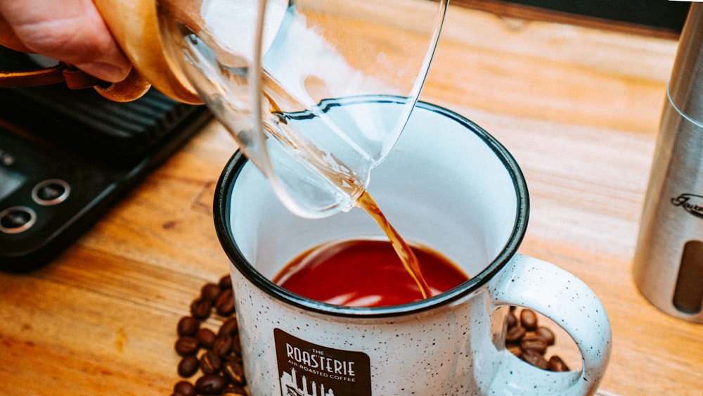 a person pours coffee into a mug