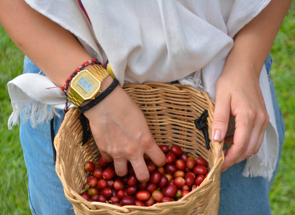 a woman holding a basket full of cherries
