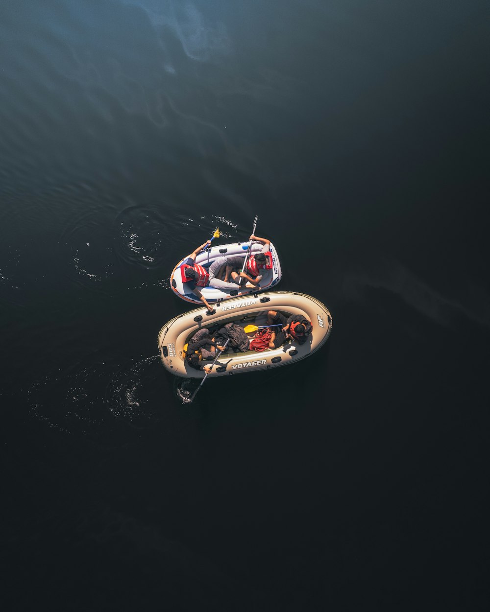 two small boats floating on top of a body of water