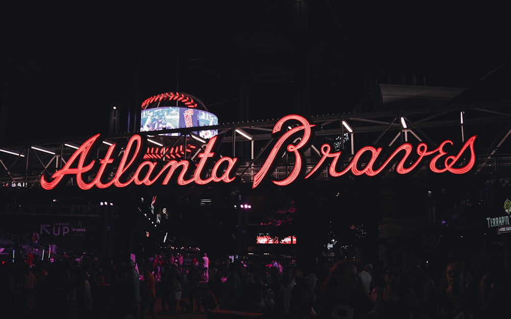 a crowd of people standing around a neon sign