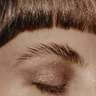 a close up of a woman's eye with glitter on it