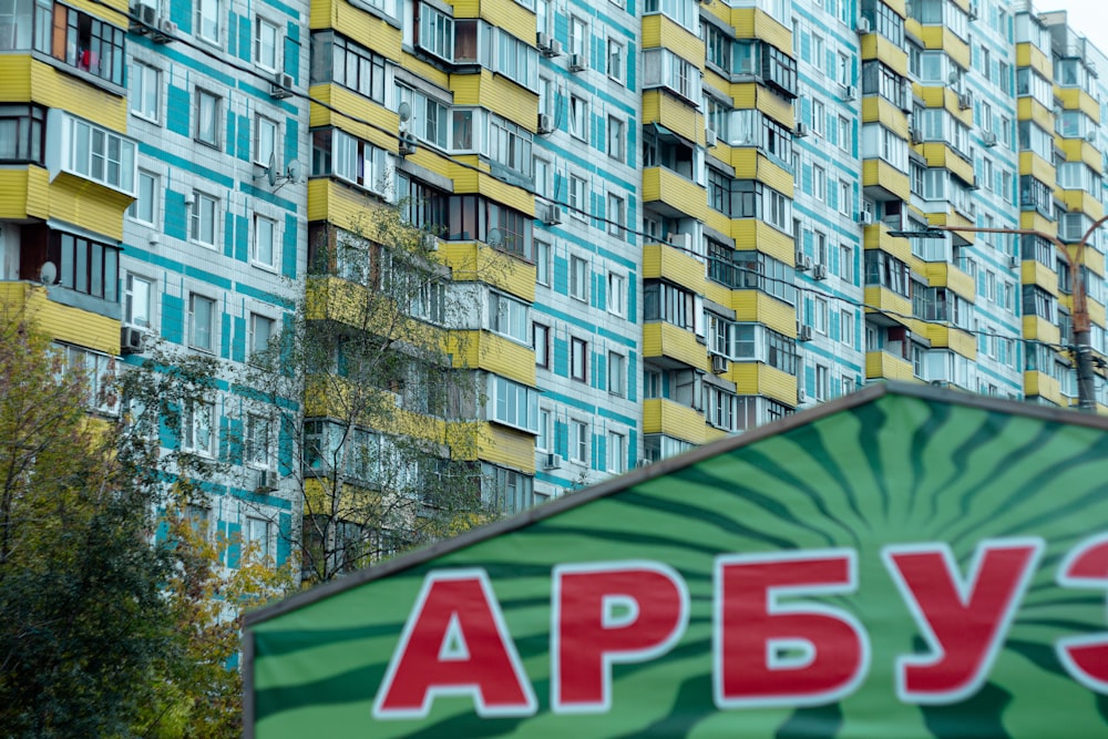 a green and yellow building with a sign in front of it