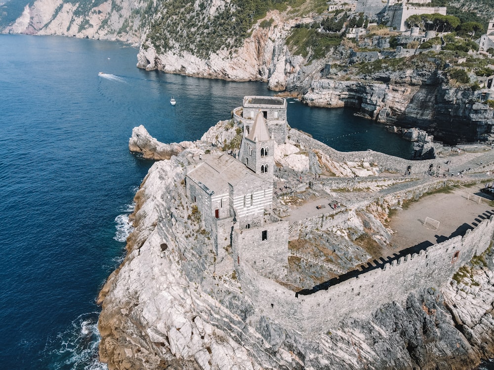 an aerial view of a building on a cliff near the ocean