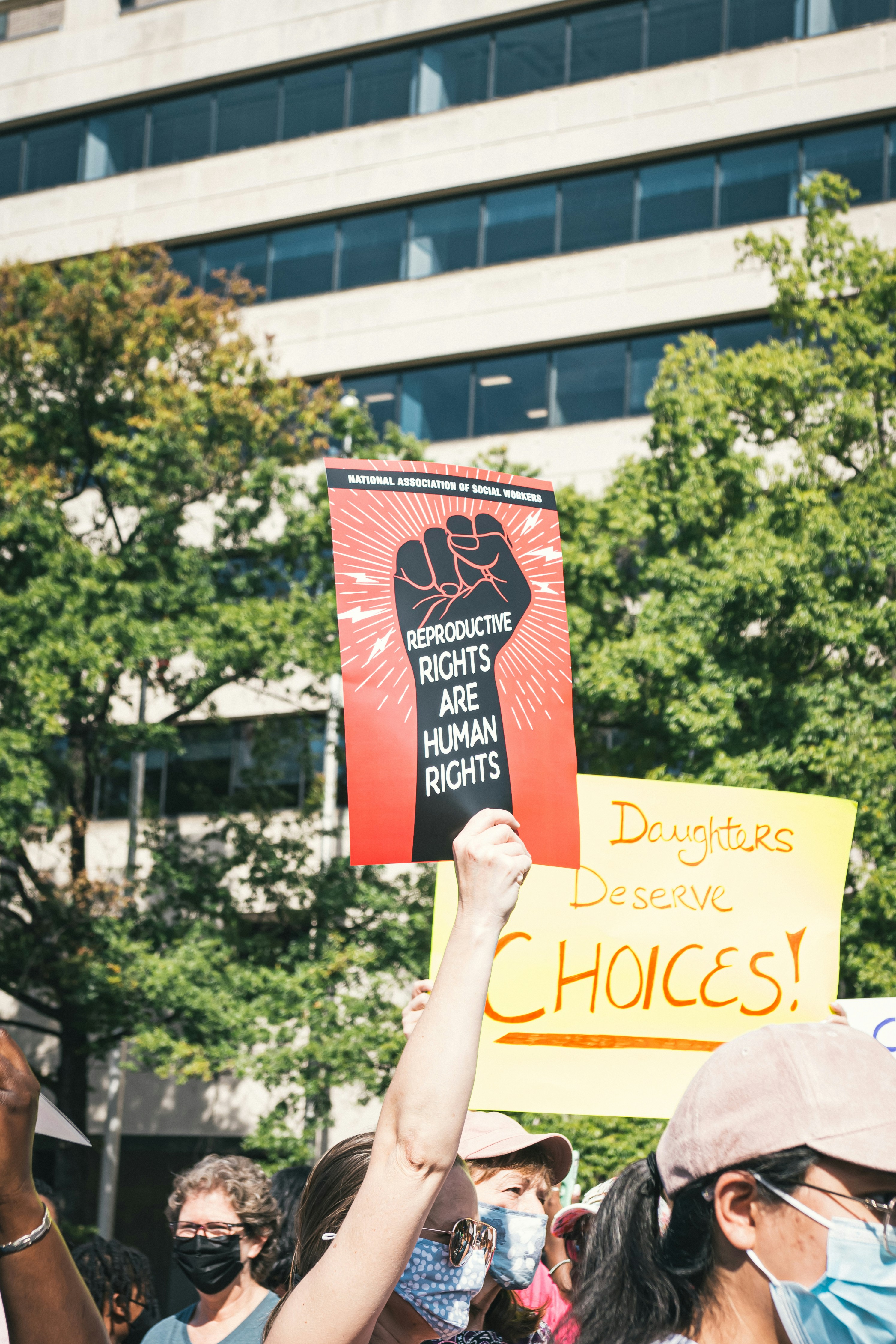 a group of people holding up signs in front of a building