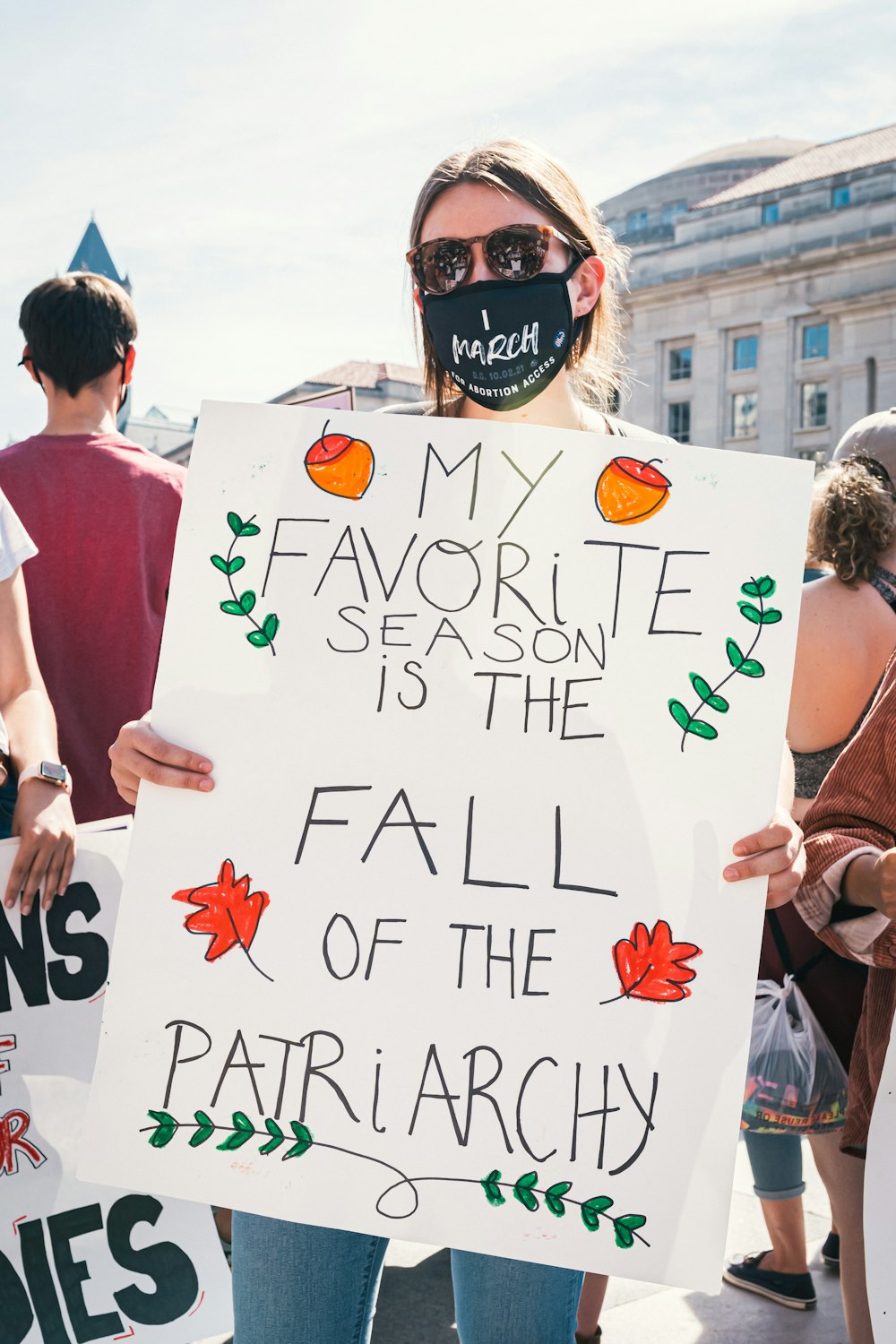a woman holding a sign that says my favorite season is the fall of the par