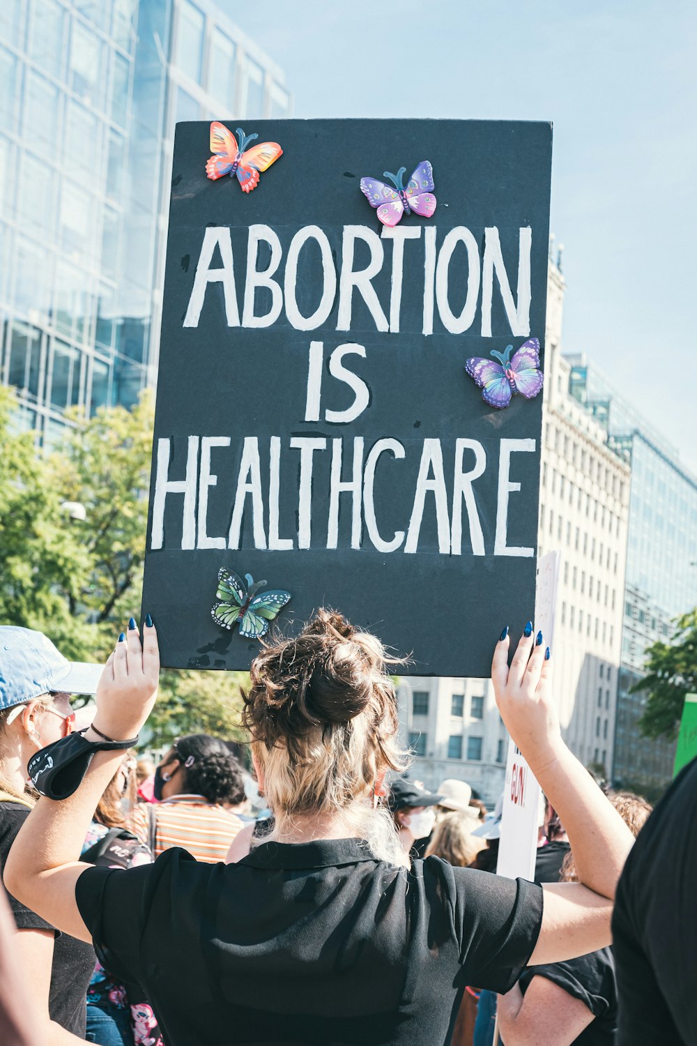 Una mujer sosteniendo un cartel que dice que el aborto es atención médica