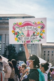 a woman holding a sign that says not your baby, not your choice