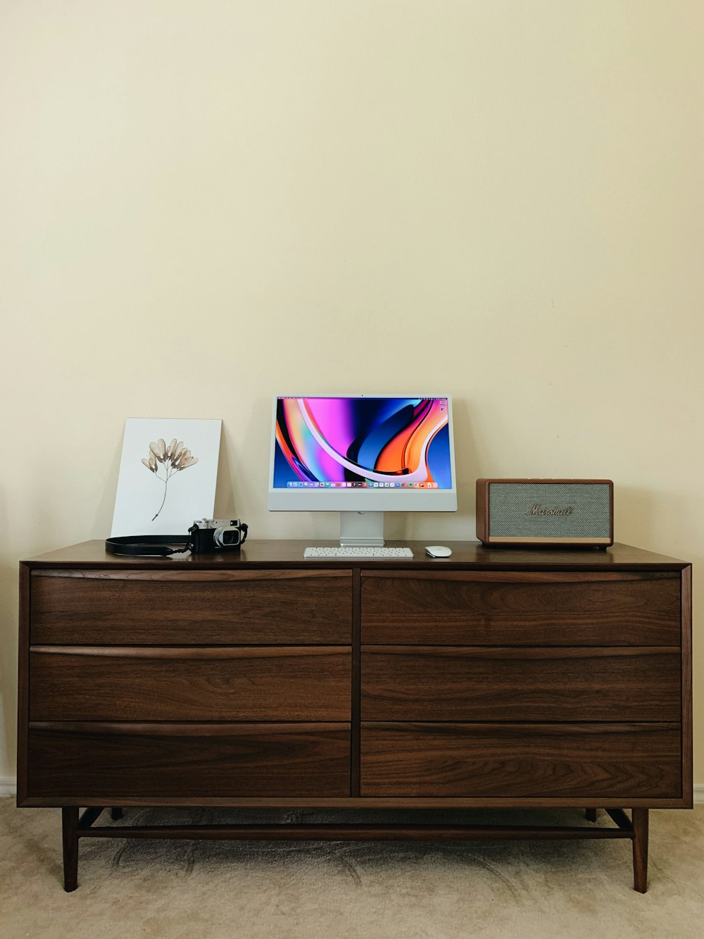 a computer monitor sitting on top of a wooden dresser
