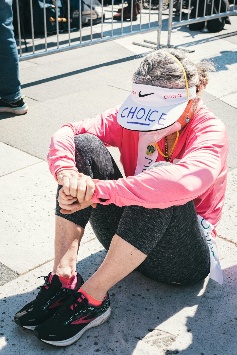 Eine Person, die mit einem Schild im Gesicht auf dem Boden sitzt