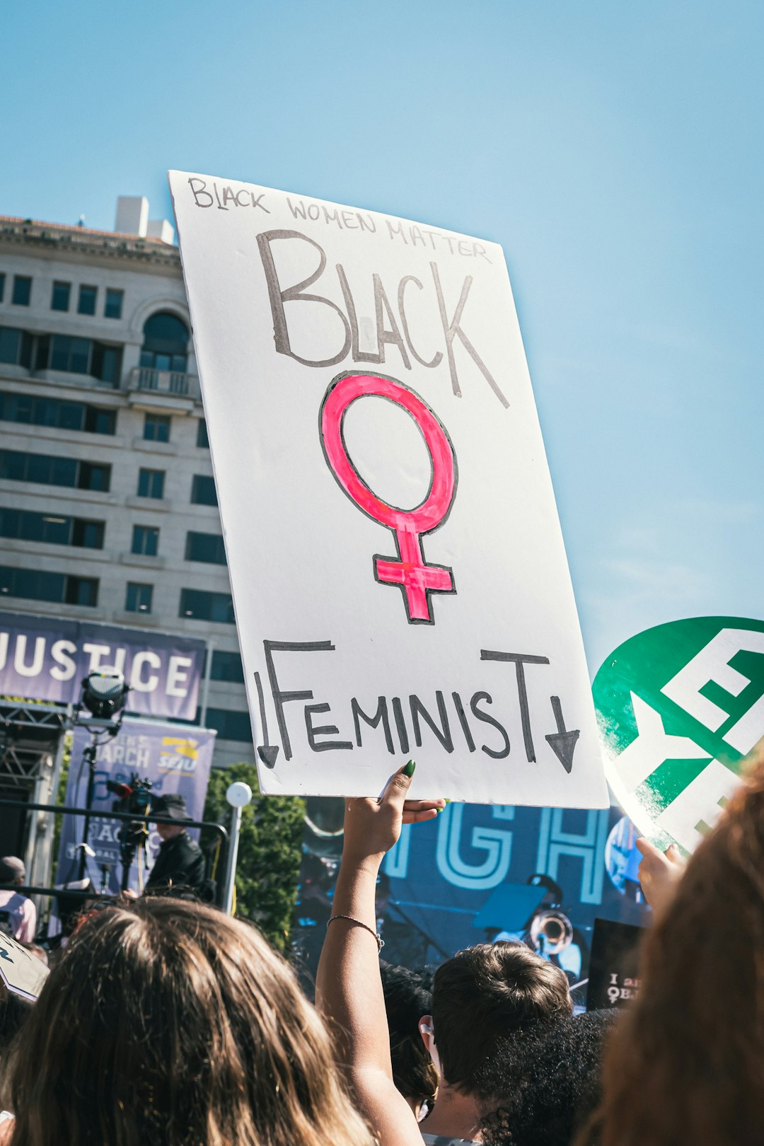 a woman holding a sign that reads black feminist
