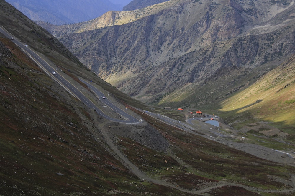 a winding mountain road in the middle of a valley