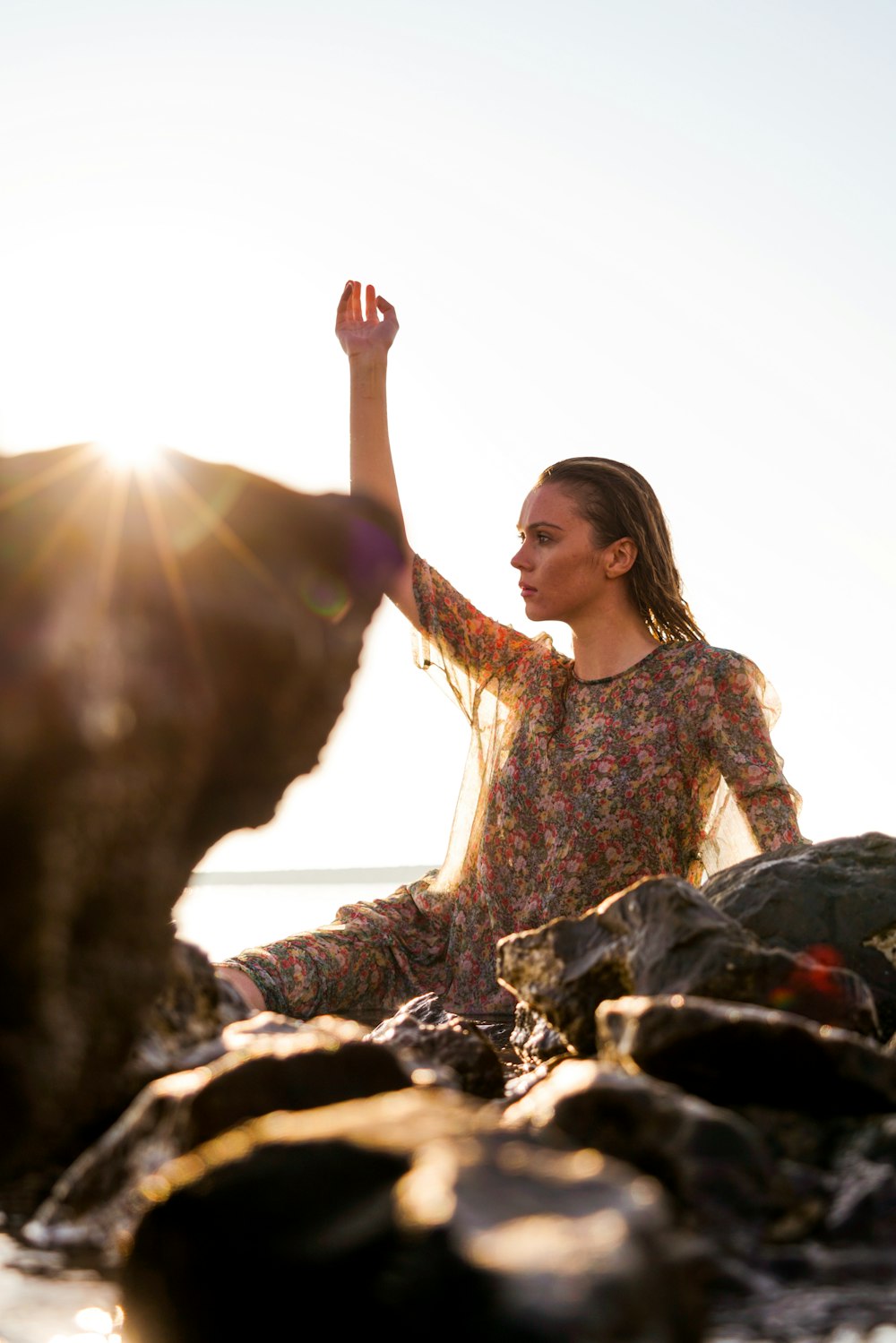 a woman sitting on a rock with a dog