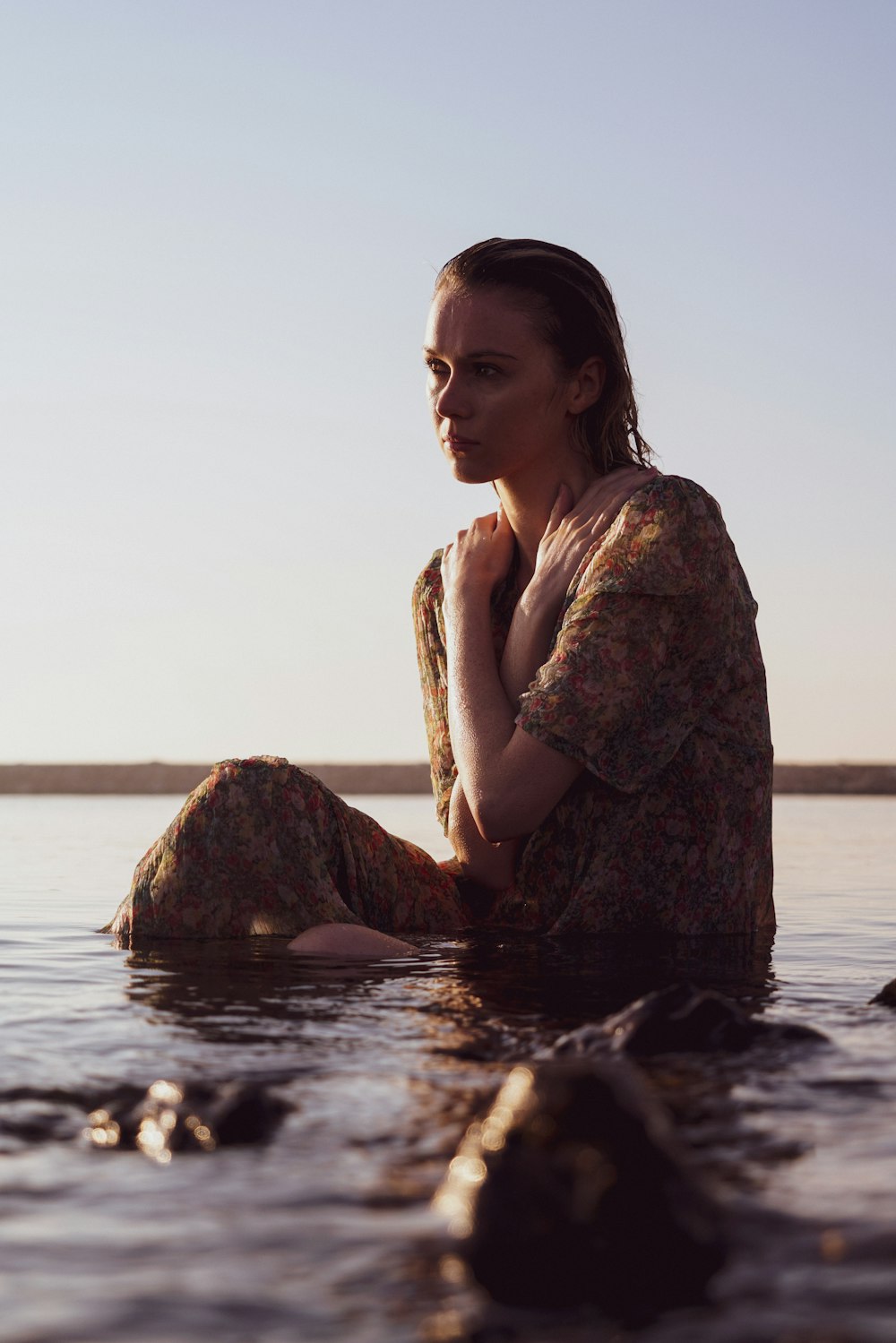 a woman sitting in the water with her legs crossed