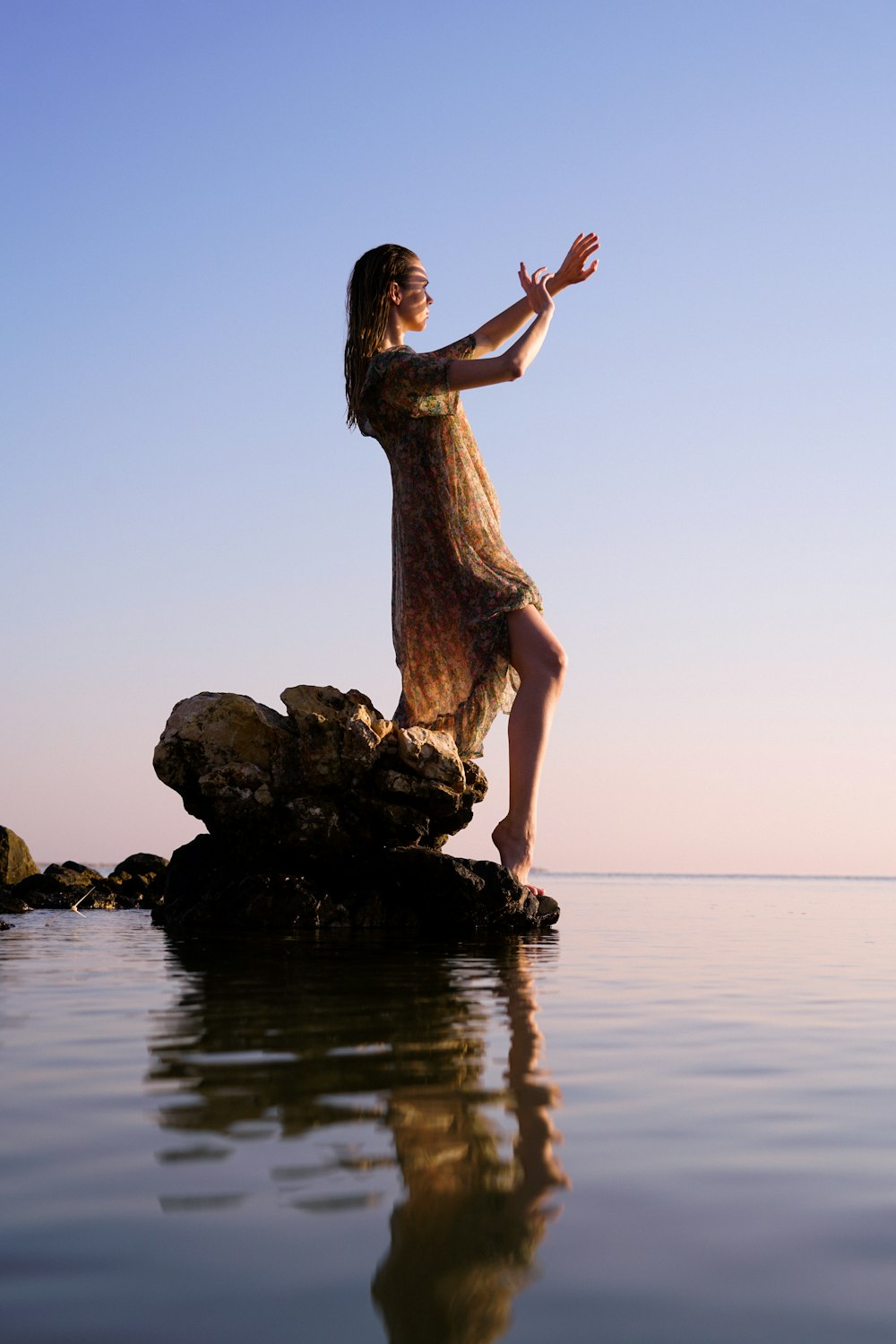 a woman standing on a rock in the water
