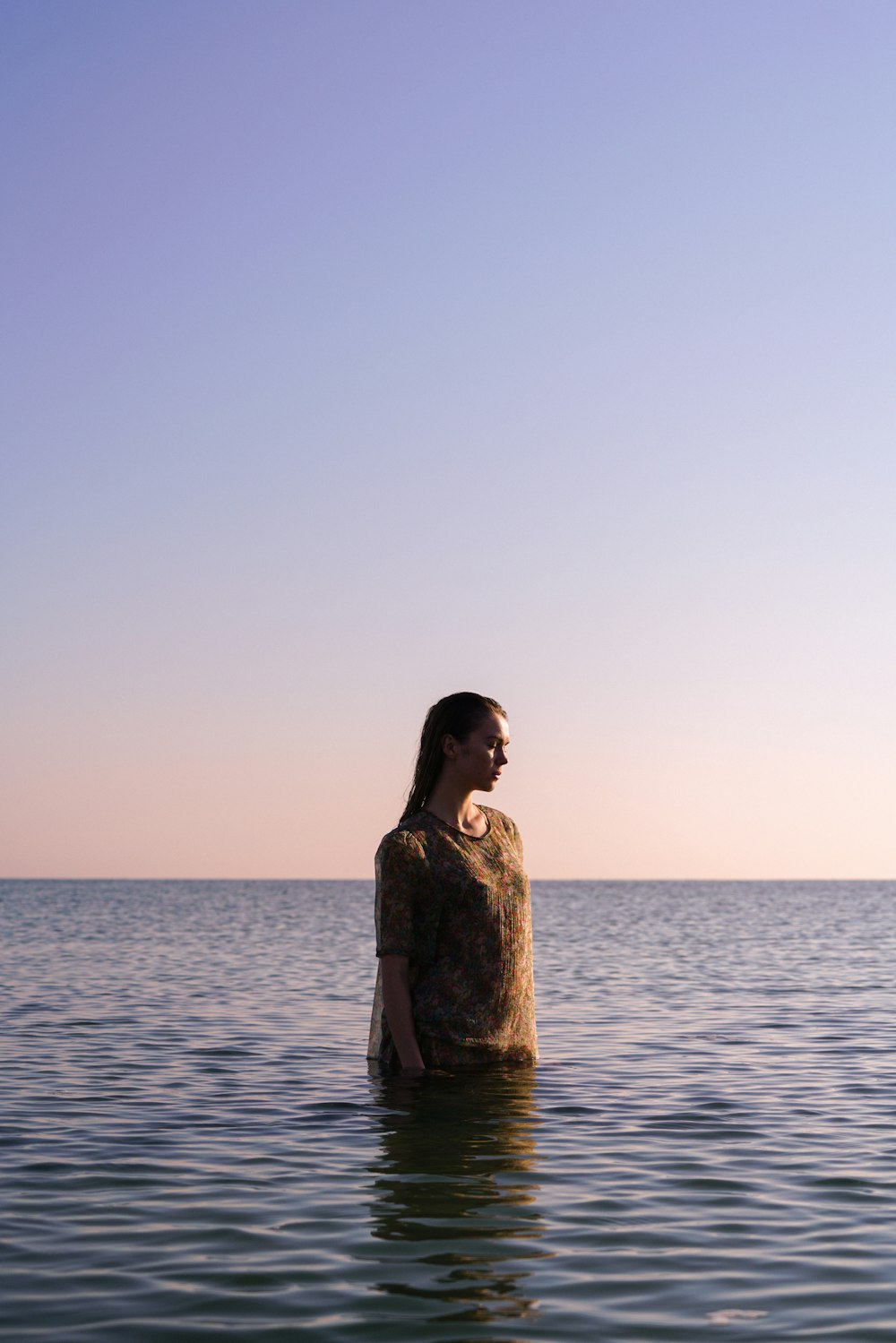 a woman standing in the middle of a body of water