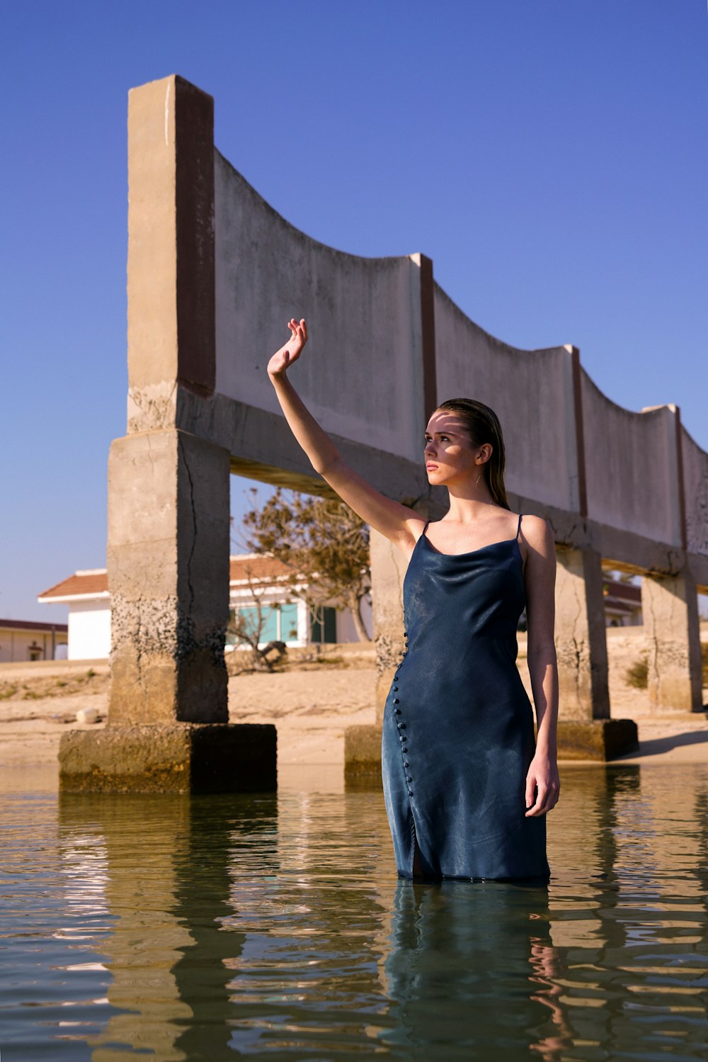 a woman in a blue dress standing in a body of water