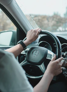 a man driving a car with his hands on the steering wheel