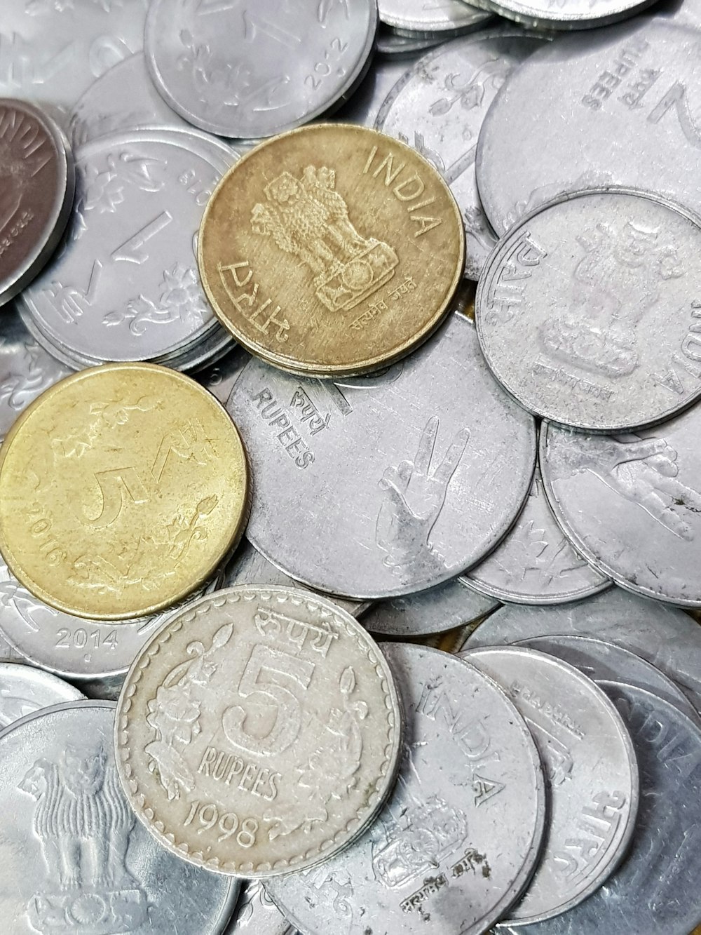 a pile of british coins sitting on top of each other