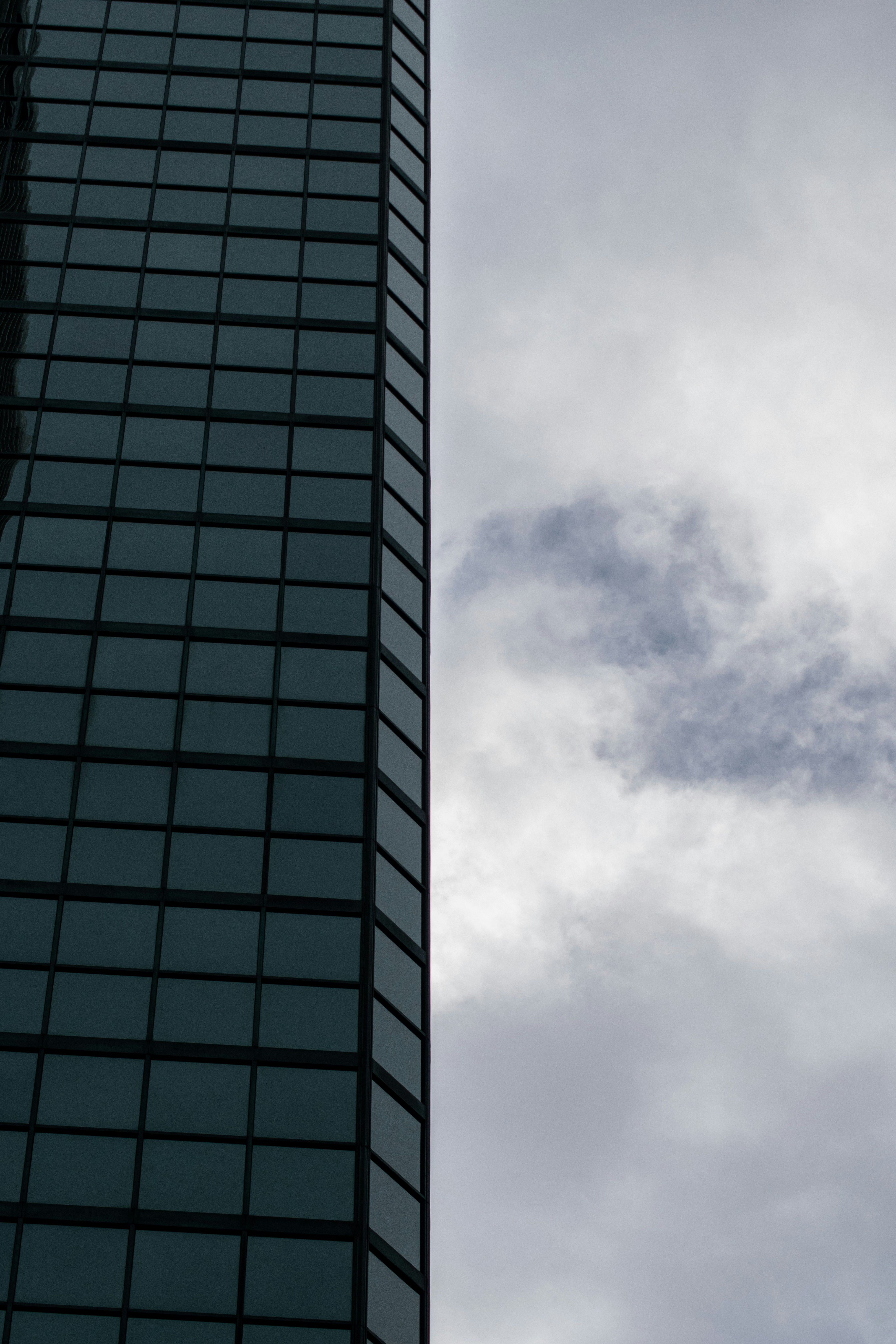 a plane flying in the sky next to a tall building