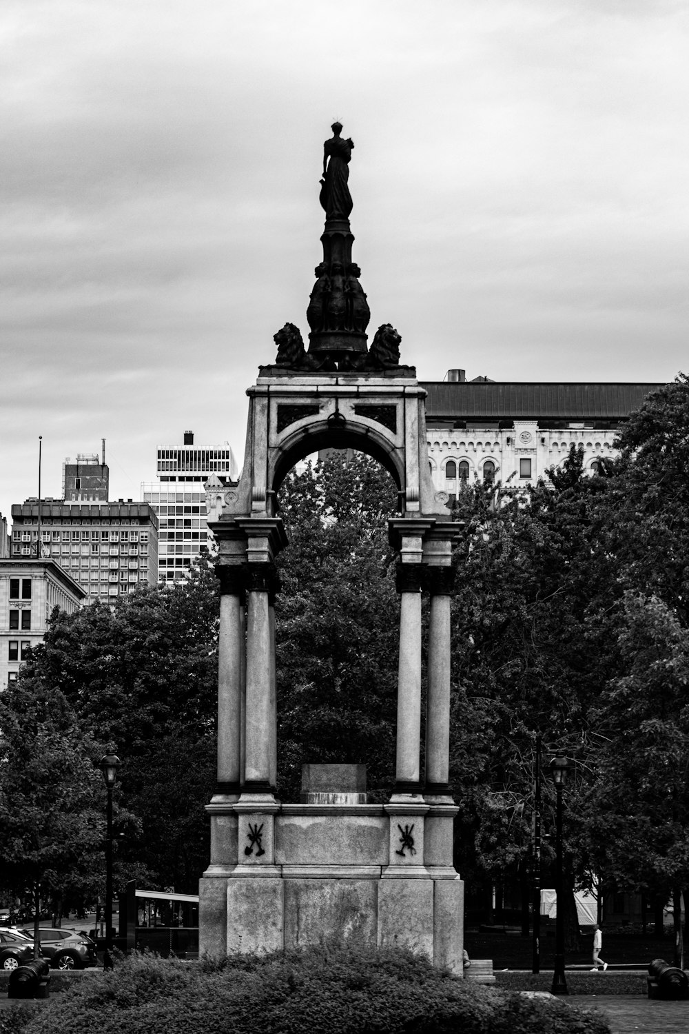 a black and white photo of a statue in a park