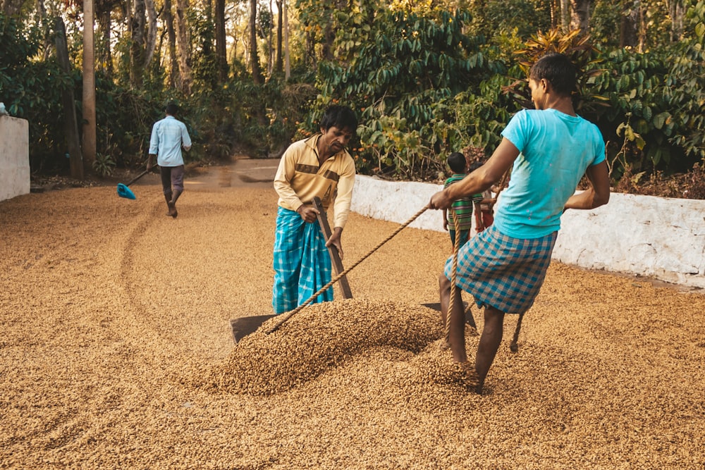 two women are working in the dirt with a shovel