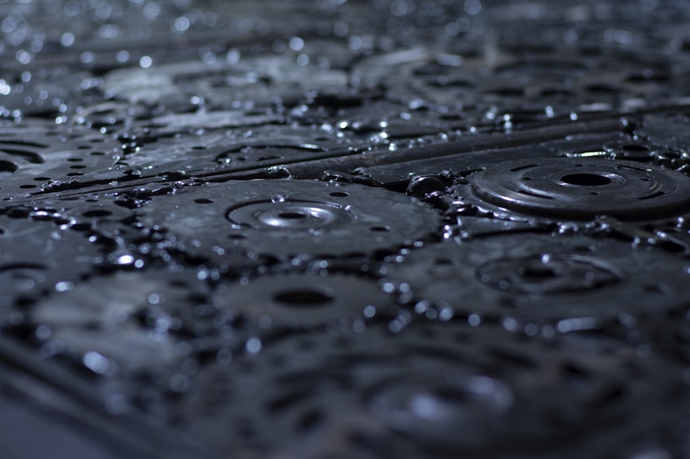 a close up of a metal grate with water droplets