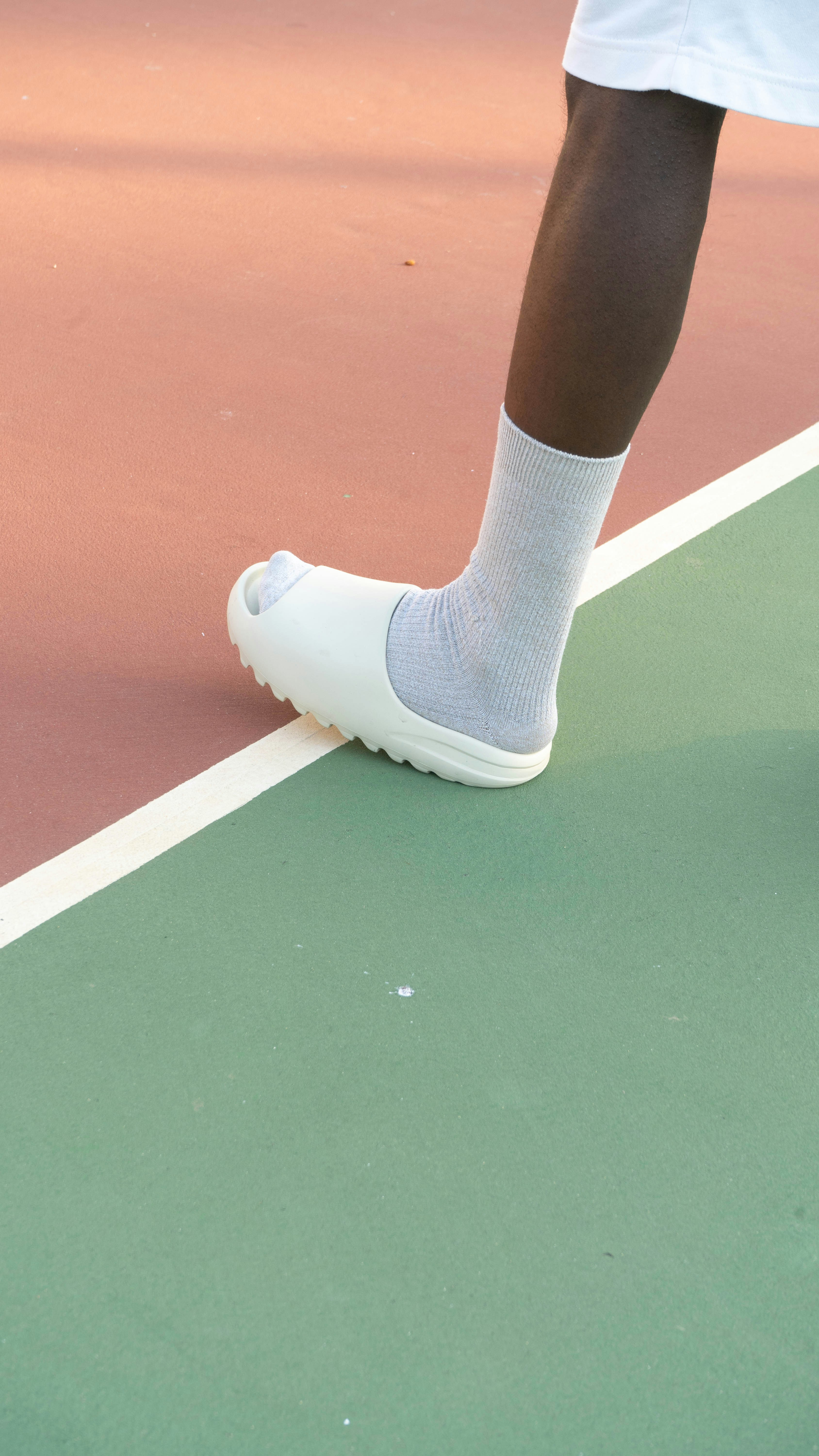 a person standing on a tennis court holding a tennis racquet