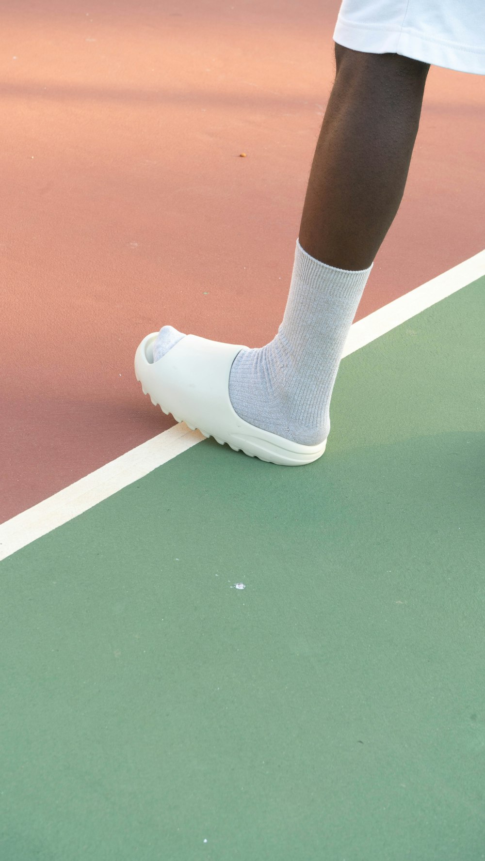 a person standing on a tennis court holding a tennis racquet