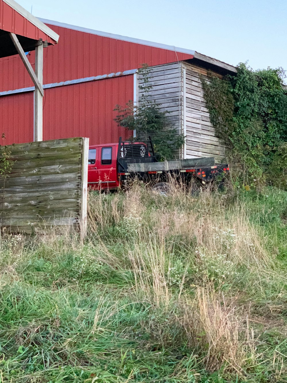 a red truck parked in front of a red barn