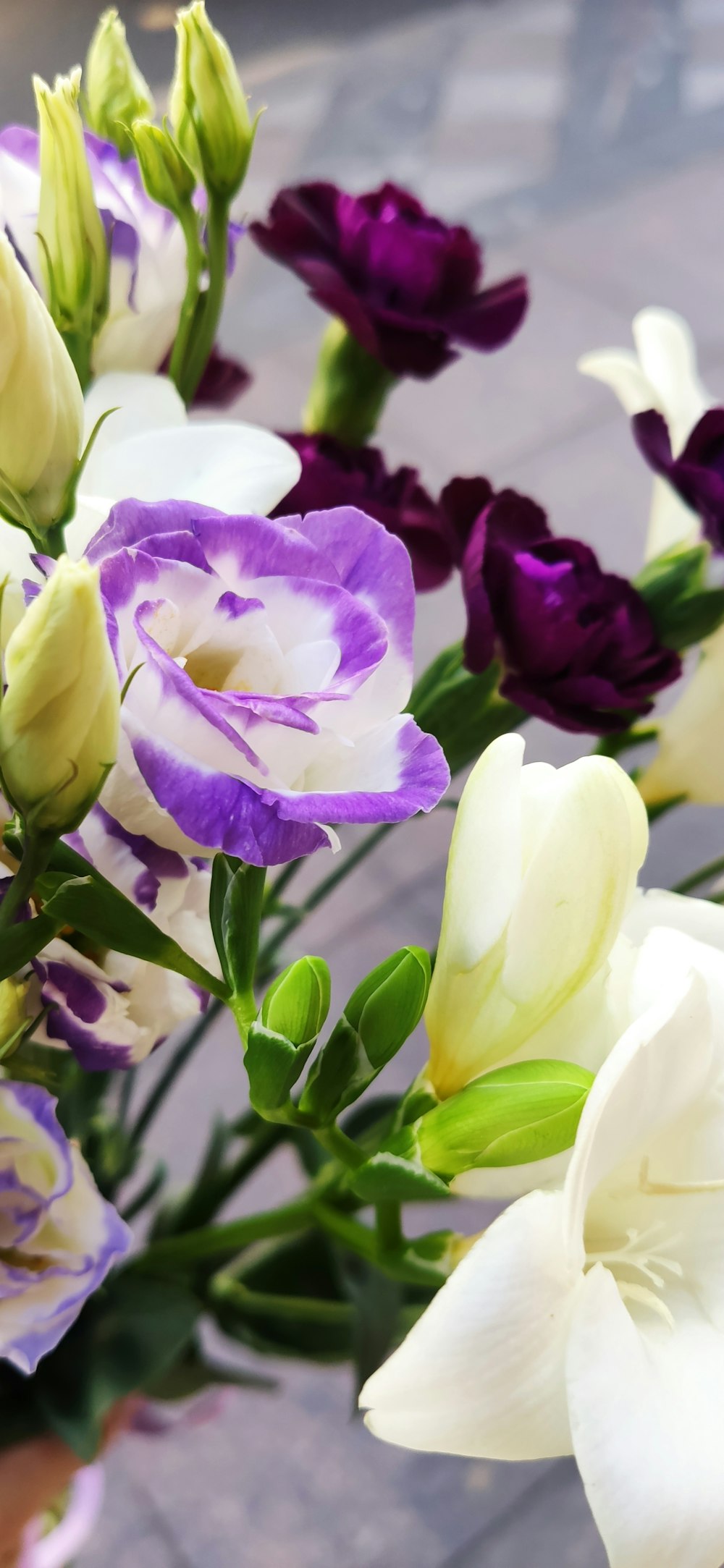 a vase filled with lots of purple and white flowers