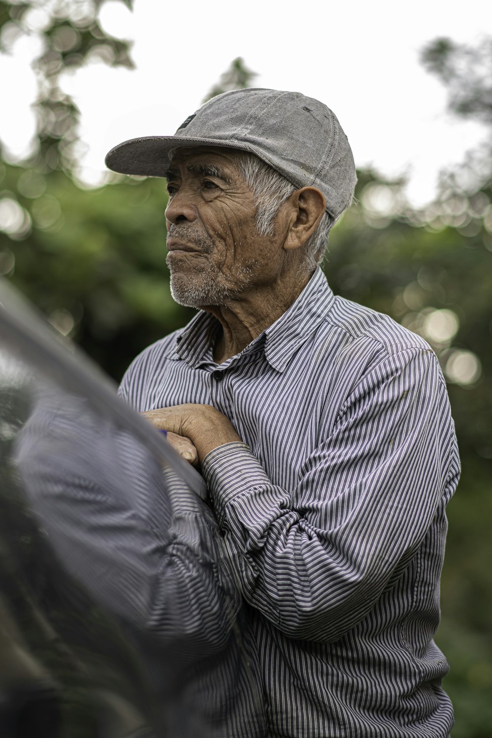 a man in a hat leaning against a car