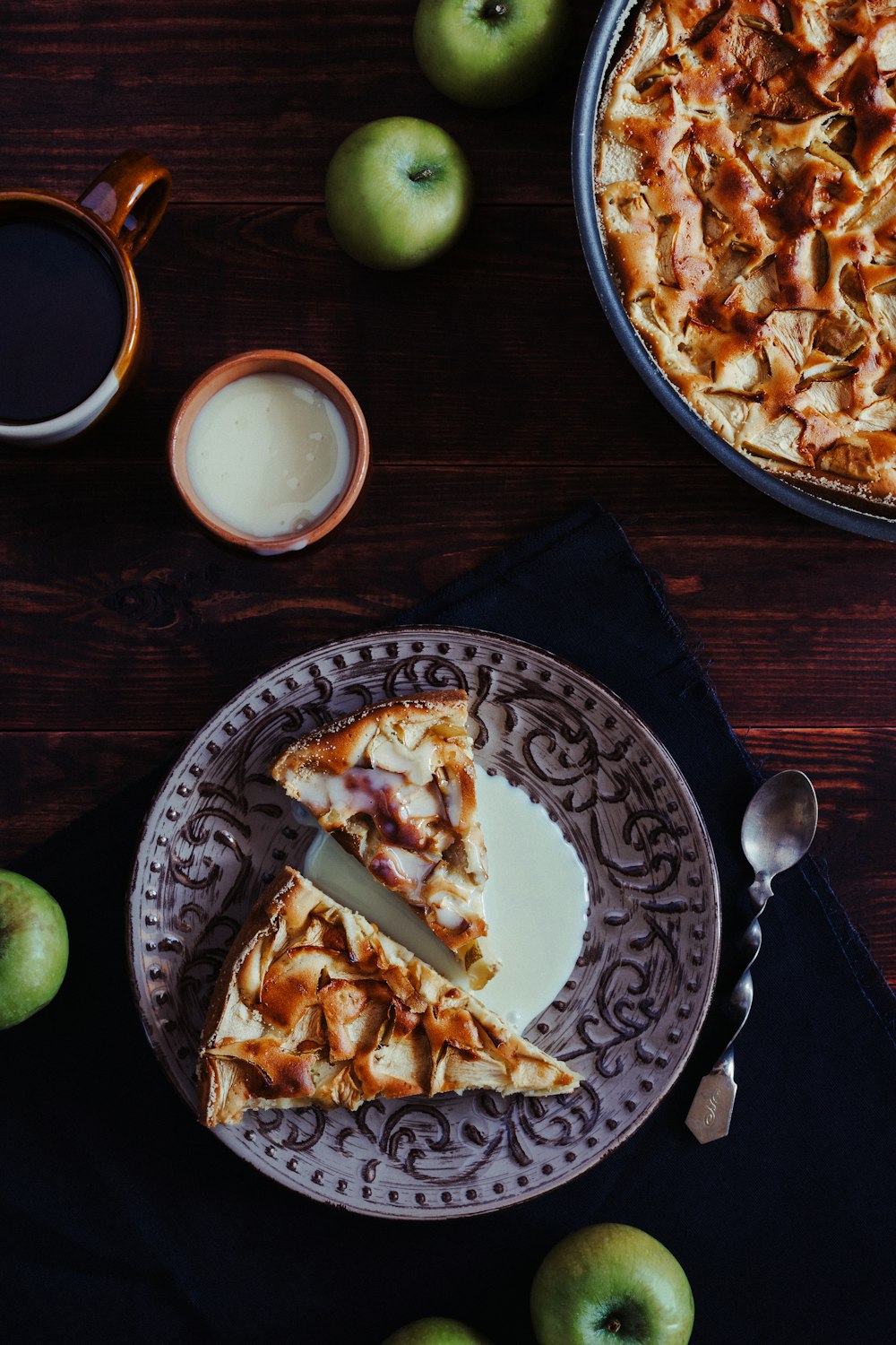 a slice of apple pie on a plate next to a cup of coffee