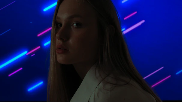Close-up of a stylish fade haircut with sharp lines under neon blue lighting.