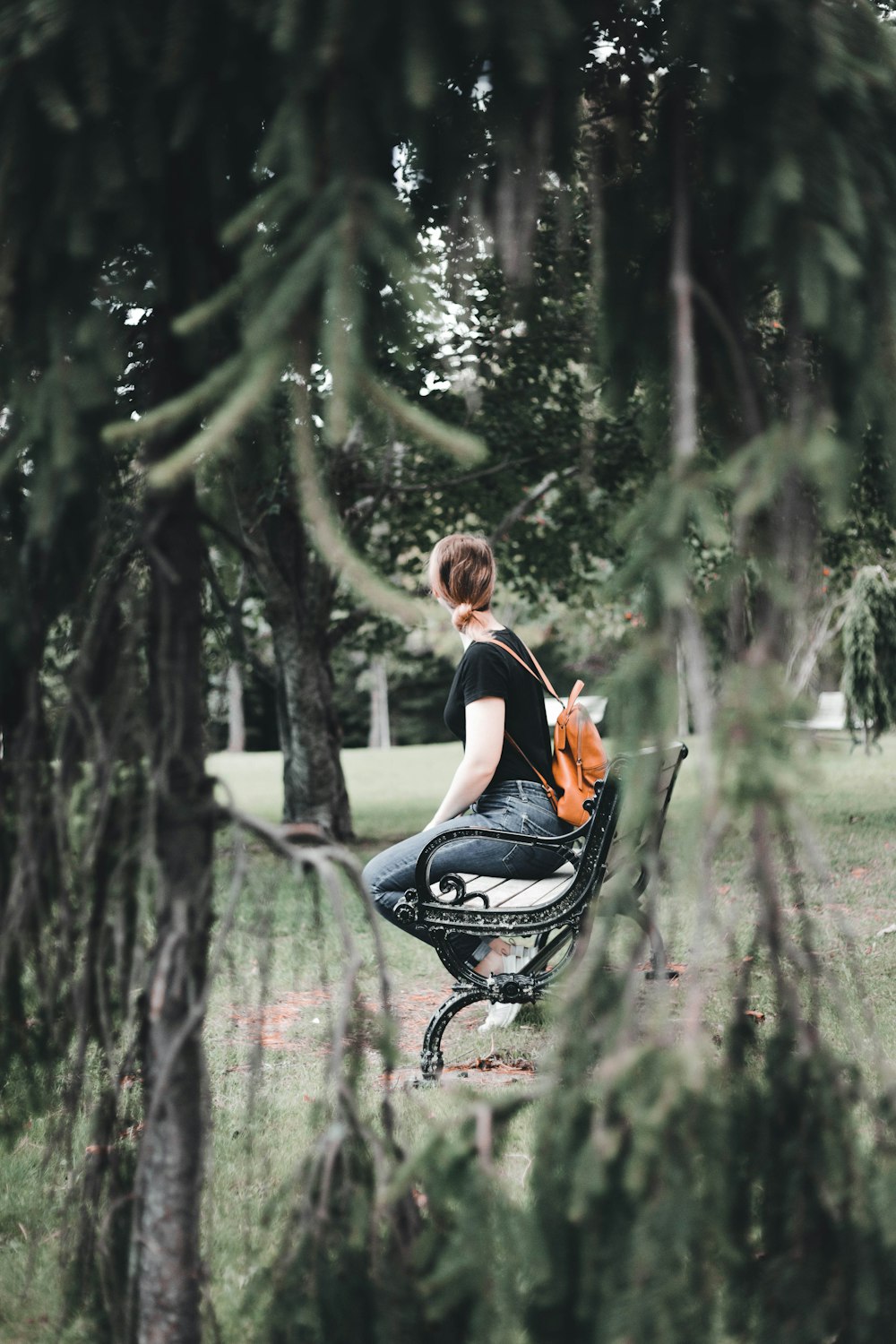 a woman sitting on a chair in a park